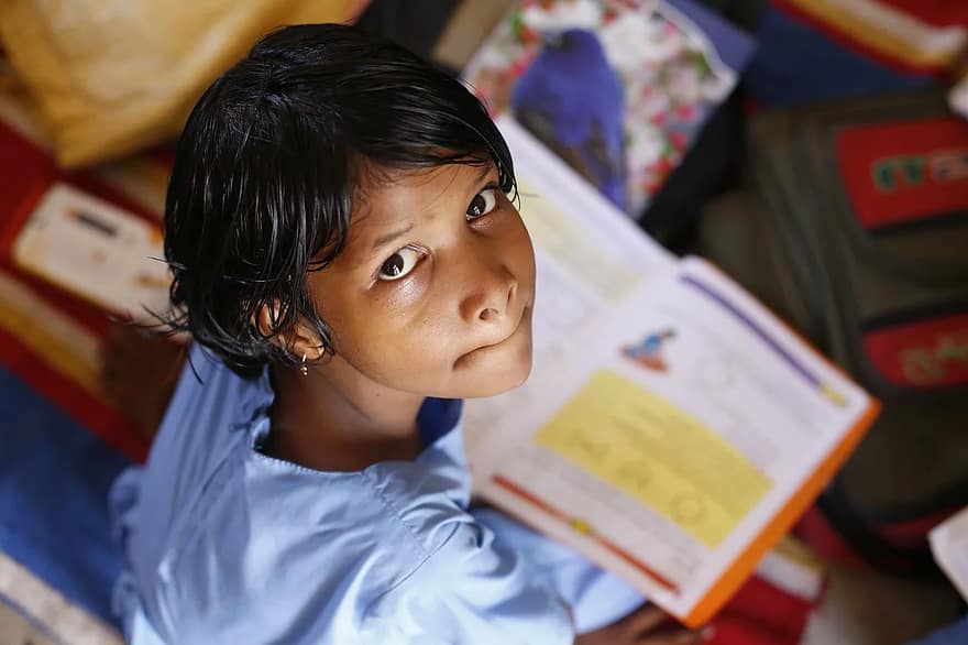 petite fille lisant un livre scolaire